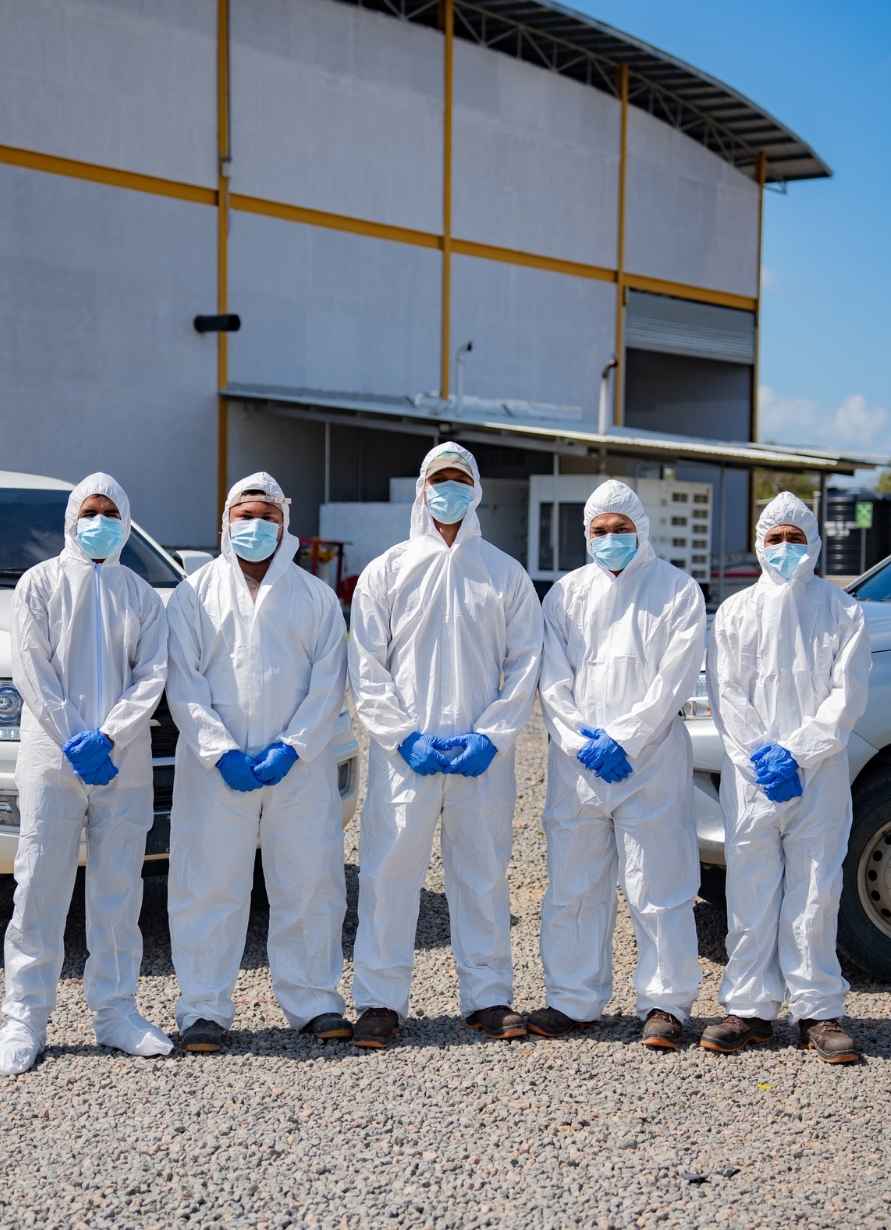 Personas con trajes de protección blanca.